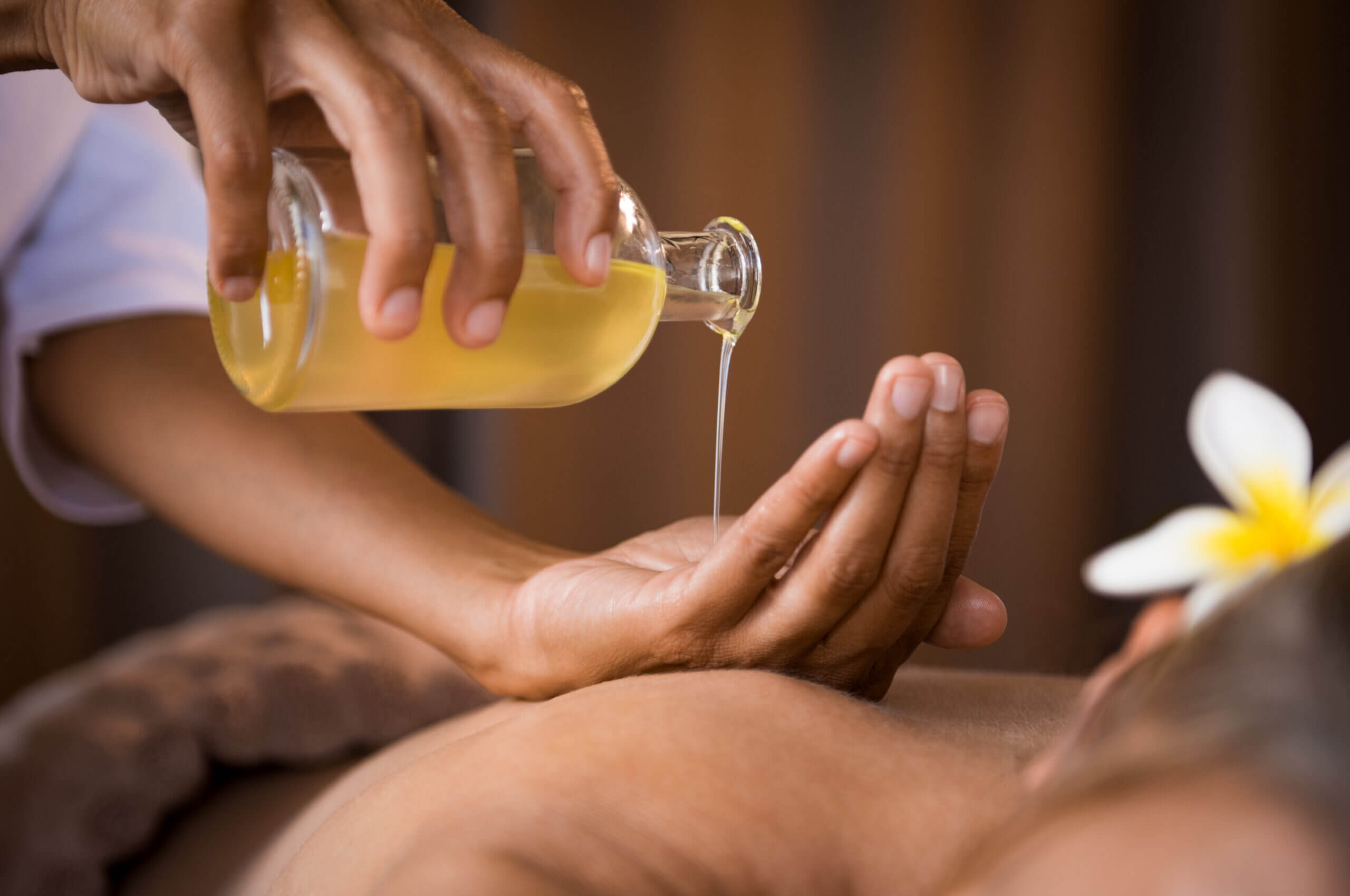 Therapist pouring massage oil at spa Therapist Pouring Massage Oil Spa Scaled 1
